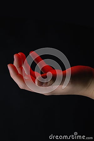 The palm from which it emits red light. Magical abilities and activation of energy in the body. Stock Photo
