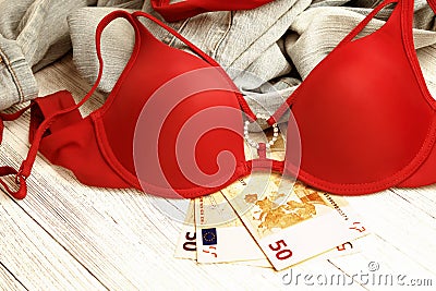 Red lingerie, jeans and money scattered on the floor. Love for money, prostitution concept Stock Photo