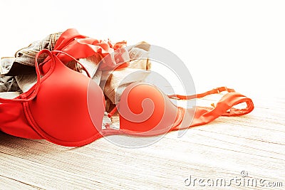 Red lingerie and jeans scattered on the floor. Messy clothes Stock Photo