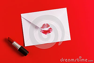 Red lipstick kiss on white envelope on red background. Stock Photo