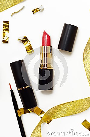 Red lipstick and lip brush top view composition. Makeup accessories and golden decorations on white background. Beauty industry Stock Photo