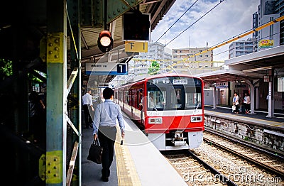 Red Local commutor train at Keikyu Kawasaki Daiji station, Japan Editorial Stock Photo