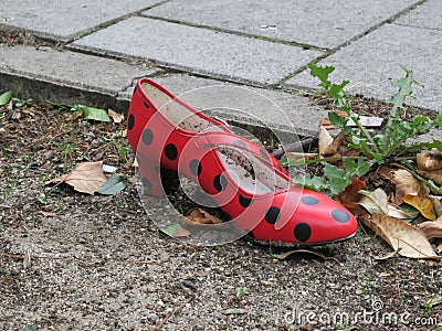 Red lonely dancing shoe with black post lost in the street Stock Photo