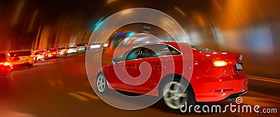 Red luxury car speeding up in night city. Traffic. Motion Stock Photo