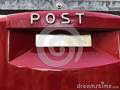 Red mailbox on a brick wall with Post text on it close-up. mailing concept Stock Photo