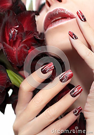 Red manicure with white wavy lines. Stock Photo