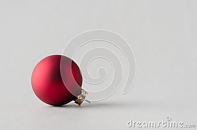 Red matte Christmas ball on a seamless grey background Stock Photo