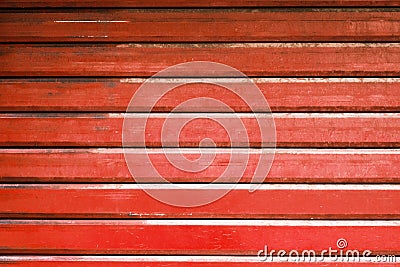 Red metal automatic garage shutter closeup, steel striped sliding door, texture and pattern, old and weathered surface, dirty Stock Photo