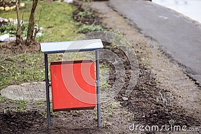 Red metal litter bin on the sidewalk Stock Photo