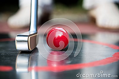 Red minigolf ball and an iron racket at a minigolf court Stock Photo
