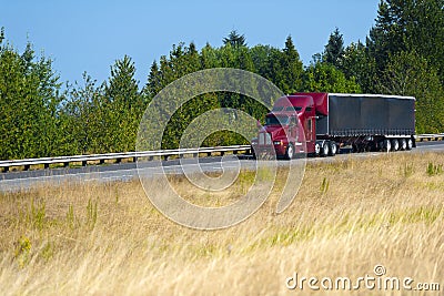 Red modern semi truck and black tarp trailer Stock Photo