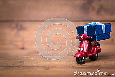 Red motorcycle vespa are Transporting Blue gift box on old and v Stock Photo