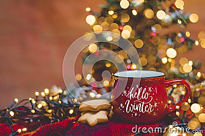 Red mug of hot coffe with Christmas lights, fresh cookies, cream, cinnamon and straw Stock Photo