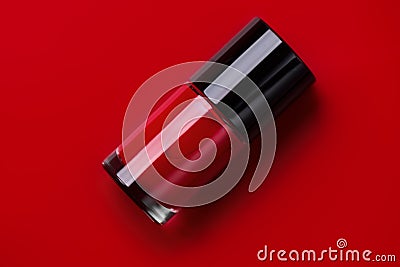 Red nail polish bottle over bright red background, top view. Gel nailpolish, shellac UV, bottle with brush Stock Photo