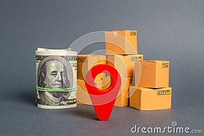 Red navigational location designator, cardboard boxes and a Roll bundle of dollars. Business and commerce. Local economy Stock Photo