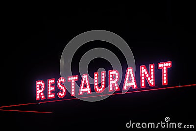 Red neon restaurant sign glowing in the night Stock Photo