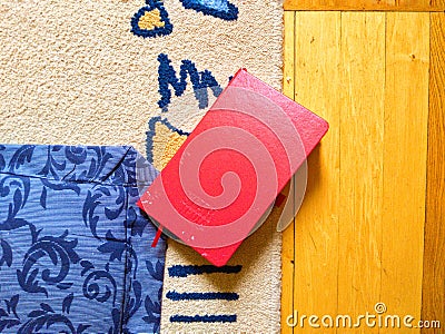 red notebook lies on the carpet Stock Photo