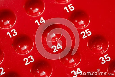 Red numbered bingo game board close-up detail, empty slots holes for bingo or lottery, random number sequence concept, row, game Stock Photo