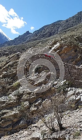 A red off-road car climbing up mountain on a dangerous rocky road Editorial Stock Photo