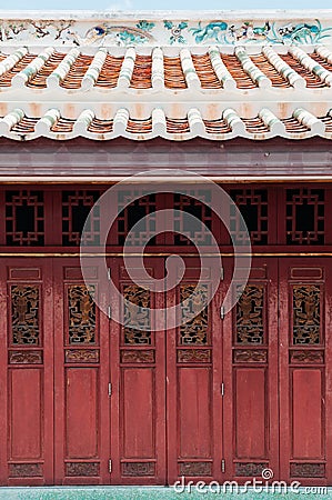 Red old carved wooden Chinese folding door of Wat Ratchaorotsaram Bangkok Stock Photo