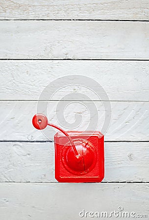 Red old vintage mechanical coffee grinder on white wooden Stock Photo