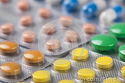 Red and orange, green pills in a silver plastic packaging Stock Photo