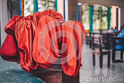 Red orange offertory bags at the back of the church. Stock Photo