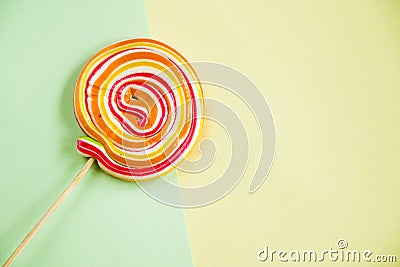 Red-orange twisted lollypop on the bicolor background with a copy space Stock Photo