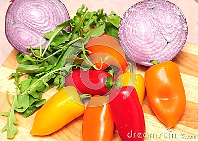 Red, orange and yellow peppers, onions and salad Stock Photo