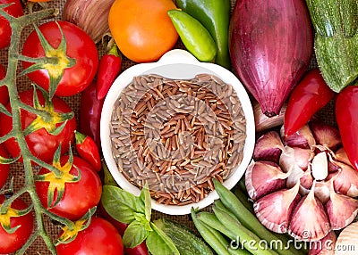 Red organic rice in bowl and vegetables Stock Photo