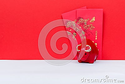 Red Ox Piggy Bank and Red Envelope With Chinese Script Happy Chinese New Year Stock Photo