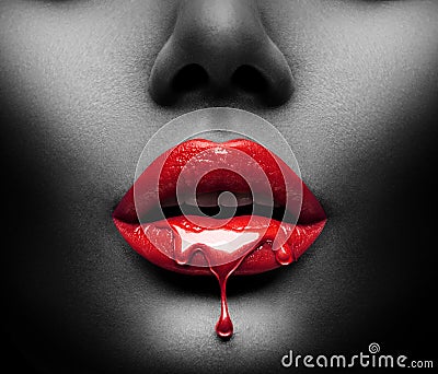 Red Paint drips from the lips, lipgloss dripping from sexy lips, bright liquid drops on beautiful model girl`s mouth, black skin Stock Photo