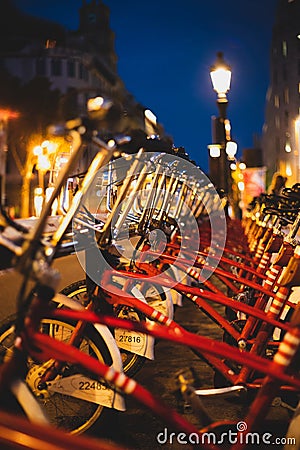 Red parked rental bikes at night perspective shot Stock Photo