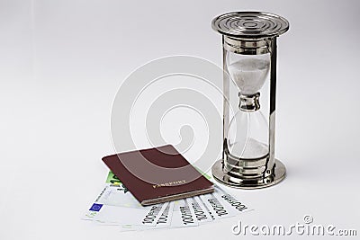 Red passport with euro banknotes and hourglass on a white background. Stock Photo