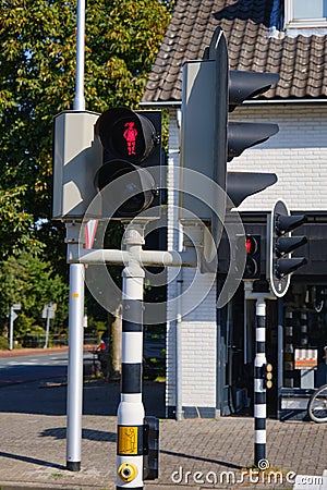 Red pedestrian light with a walking or waiting happy girl with ponytail at crossroads in the Netherlands. The name of Stock Photo