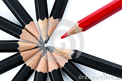 Red pencil standing out from the circle of black pencils Stock Photo