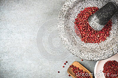 Red peppercorn seed in granite mortar or pestle Stock Photo