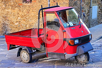 Red Piaggio Ape 50 in the street of Montalcino town, Val d`Orcia Editorial Stock Photo