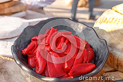 Red pickled Bulgarian pepper lies in a metal bowl Stock Photo