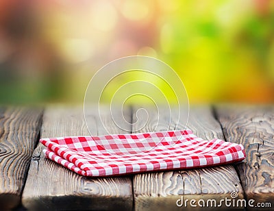 Red picnic cloth on wooden table mature bokeh background. Stock Photo