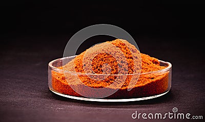 Red pigment powder with black background, industrial use in synthetic dyes Stock Photo