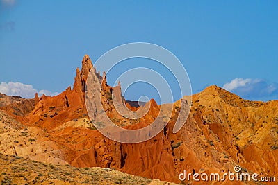 Red pinnacles of sandstone rocks at rainbow mountain canyon Stock Photo