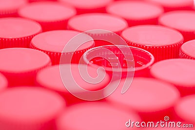 Red plastic water caps close up macro shot, one upside down Stock Photo