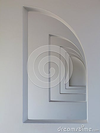 Semi arched openings in white stucco finished walls in diminishing perspective Stock Photo