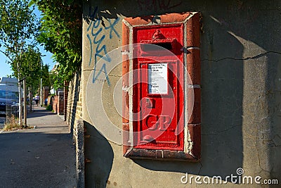 Red postbox on the wall with the GR Royal Cypher. Editorial Stock Photo