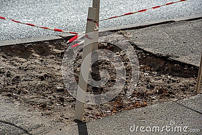 Red protective tape encloses pit on the road Stock Photo
