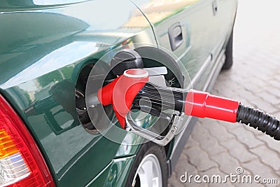Red pump for refueling filling green car Stock Photo