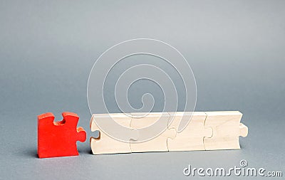 The red puzzle is disconnected from the rest. The concept of individuality and uniqueness. Individual opinion. Betrayal in the Stock Photo