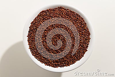 Red Quinoa seed. Top view of grains in a bowl. White background. Stock Photo
