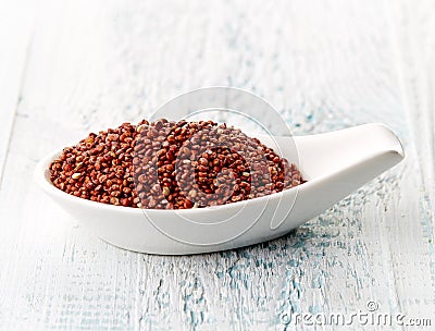 Red quinoa in white porcelain spoon Stock Photo